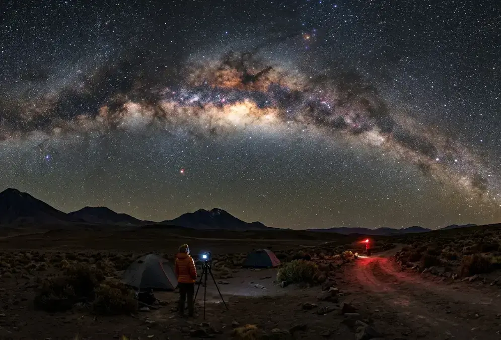 The Milky Way galactic core arching overhead in the Atacama Desert on a new-moon night, Bortle 1 sky, San Pedro de Atacama, Chile, with volcanic silhouettes on the horizon