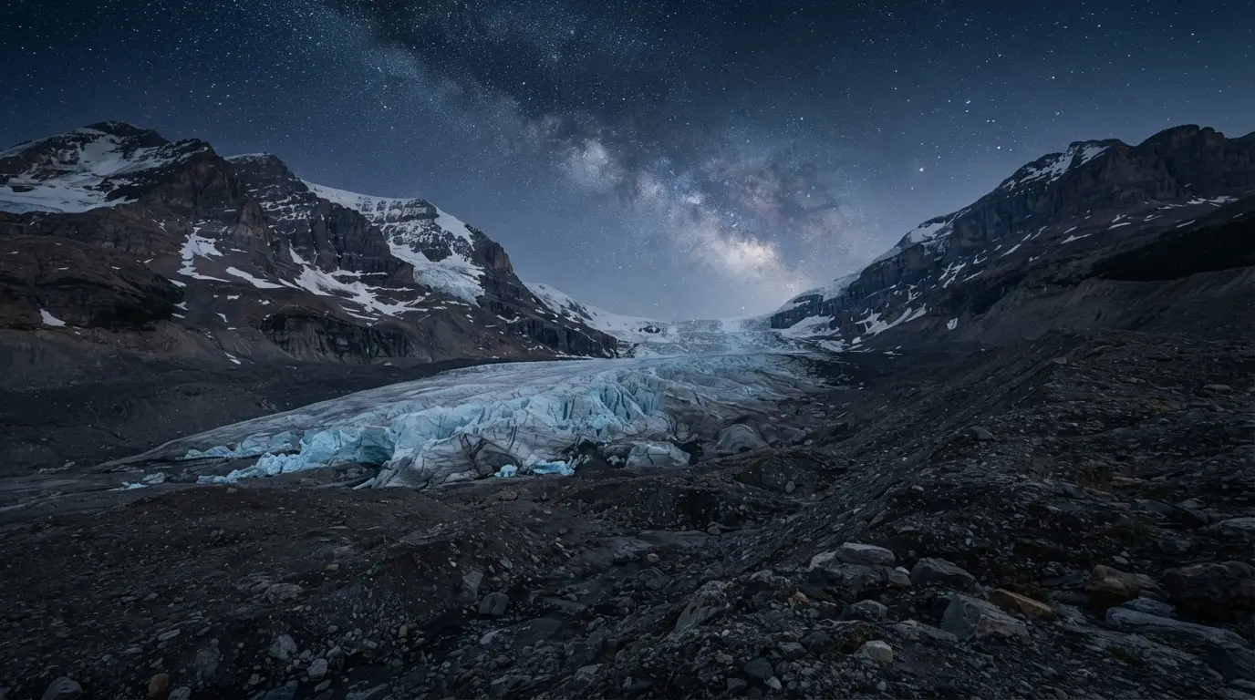 The Athabasca Glacier retreating along the Icefields Parkway, its shrinking terminus exposed beneath a star-filled night sky