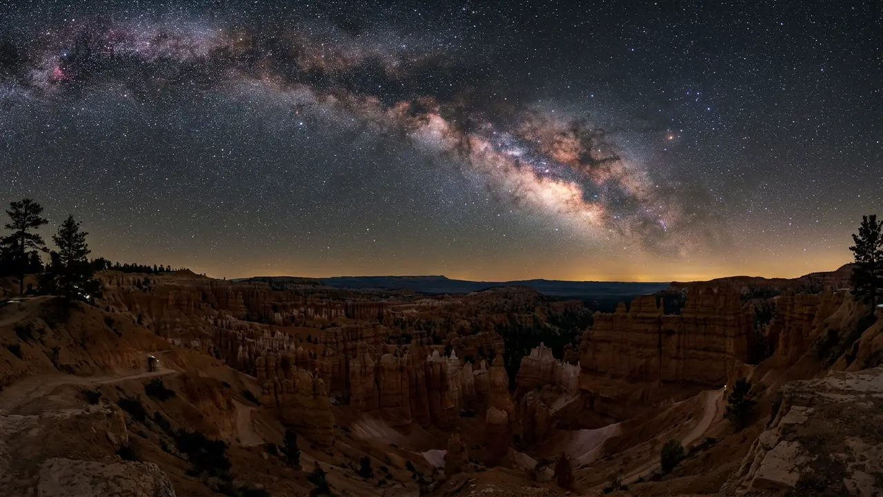 Milky Way core rising above the glowing red-rock hoodoos of Bryce Canyon Amphitheater on a clear, moonless night, illustrating the best time to stargaze at Bryce Canyon
