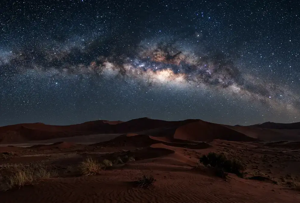Milky Way galactic core rising over red dunes in NamibRand Nature Reserve at night, illustrating the best time for stargazing in NamibRand's dry season under near-zero humidity skies