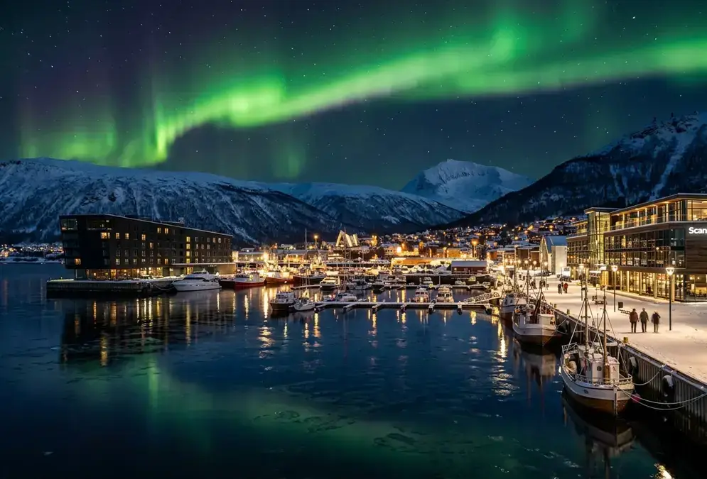 Tromsø harbour at polar night, green aurora borealis overhead, illustrating the Clarion Edge vs Scandic Ishavshotel comparison for aurora hunters staying on the Arctic waterfront