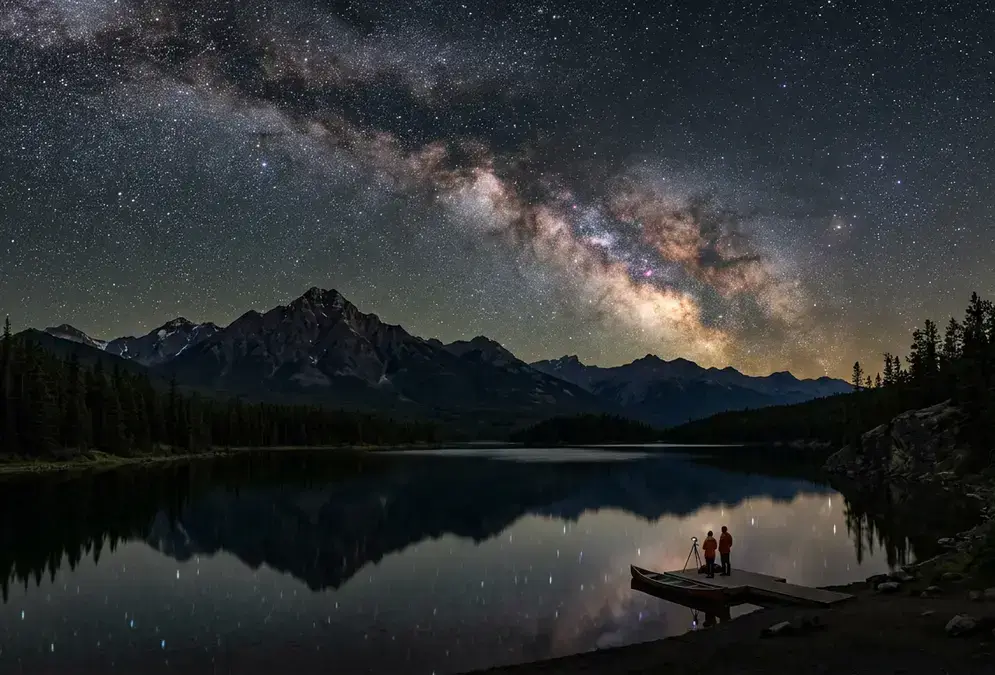 Milky Way over Pyramid Lake near Jasper, Alberta at night, illustrating whether Jasper is worth it for stargazing, Rocky Mountain peaks reflected in still water under a Dark Sky Preserve