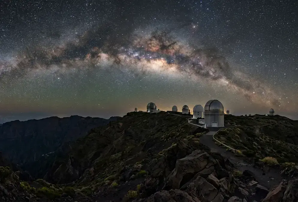 Is La Palma worth it for stargazing? Milky Way arching over the Roque de los Muchachos Observatory domes on La Palma's caldera rim, Bortle 1-2 dark sky at 2,396 metres, Canary Islands